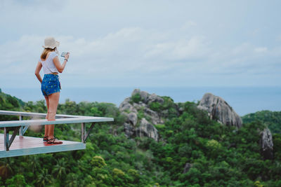 Rear view of woman looking at sea while standing on observation point