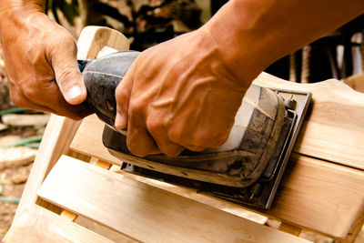 Close-up of hands working on wood