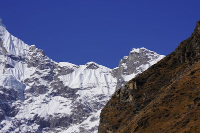 Scenic view of snowcapped mountains against clear blue sky