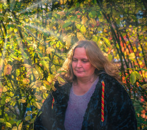 Posing of a female model in the forest in front of autumn leaves to the autumn beginning