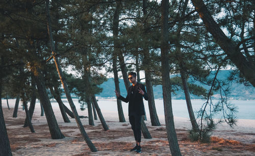 Young woman standing on tree trunk