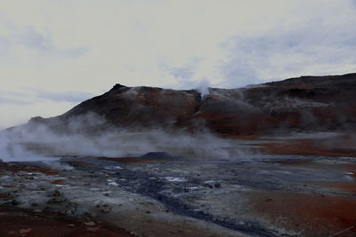 Smoke emitting from volcanic mountain against sky