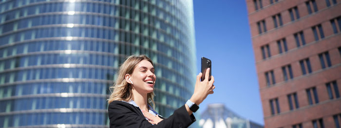 Low angle view of businesswoman using mobile phone
