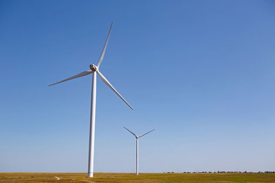 Group of electric windmills stands in a field in the summer in crimea