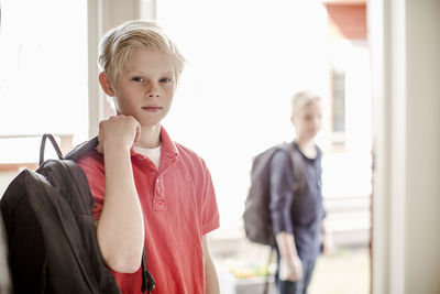 Portrait of confident boy with backpack leaving for school