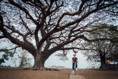 Full length of man standing by tree