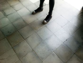 Low section of man standing on tiled floor