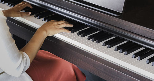 Midsection of woman playing piano