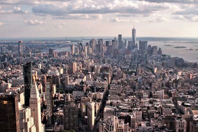 High angle view of city buildings against cloudy sky