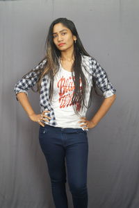 Portrait of a beautiful young woman standing against wall