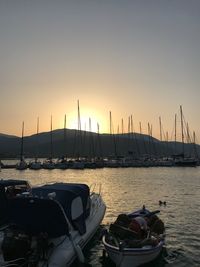 Sailboats moored in sea against clear sky