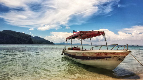 Boat moored on sea against sky