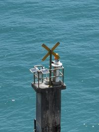 Close-up of coin-operated binoculars by sea against blue sky