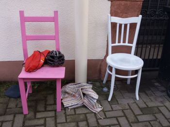 Empty chairs and table against building