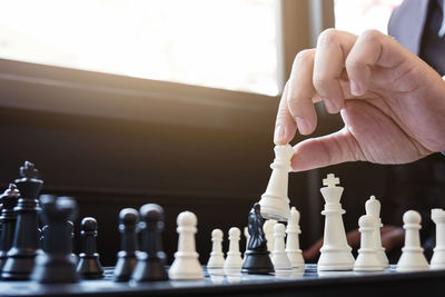 Cropped hand of man playing chess at home