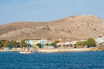 Buildings by sea against sky