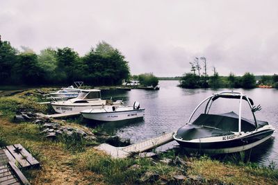 Boats moored on shore against sky