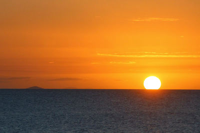 Scenic view of sea against orange sky