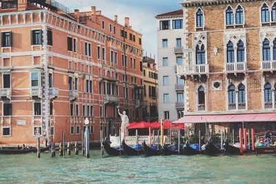 Gondola boats moored in grand canal by building