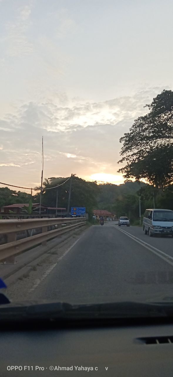 CARS ON ROAD AGAINST SKY SEEN THROUGH CAR WINDSHIELD