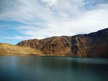 Scenic view of lake by mountains against sky