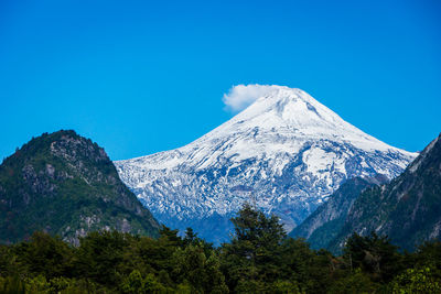 Scenic view of snowcapped mountains against blue sky