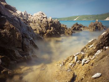 Scenic view of sea and rocks against sky