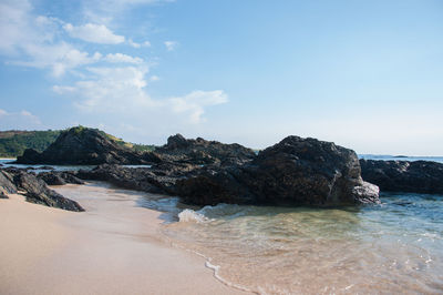 Rocks on beach against sky