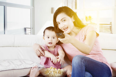 Portrait of happy woman sitting on sofa