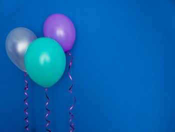Low angle view of balloons against blue sky