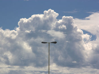 Low angle view of electricity pylon against blue sky