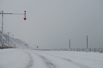 Road amidst snow covered land against sky