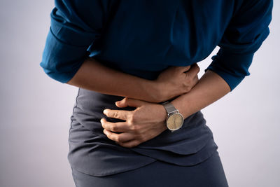 Midsection of man standing against white background