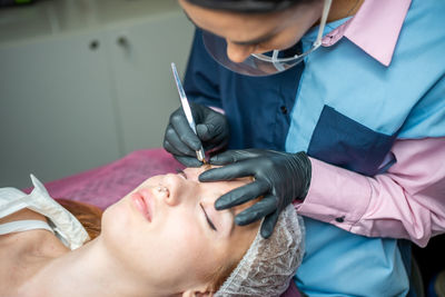 Midsection of doctor examining patient in hospital