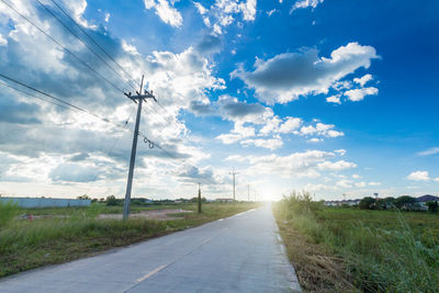 Road amidst field against sky