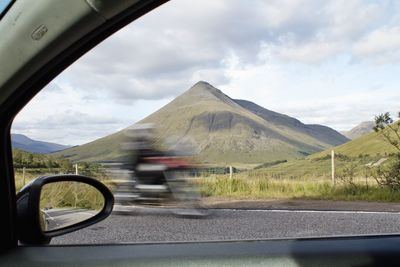 Road seen through car windshield in scotland overlooking mountain