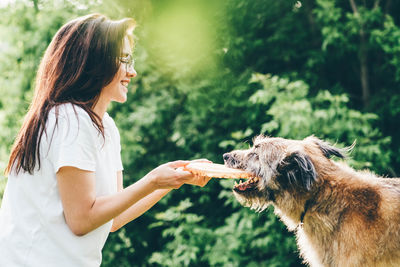 Side view of woman holding dog