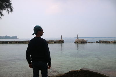 Man standing on beach against sky