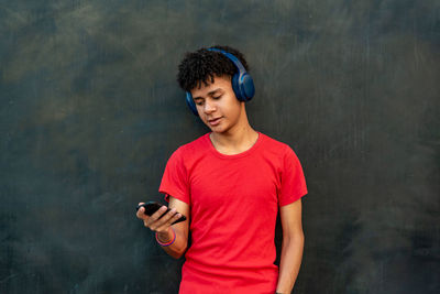 Boy listening music against black background