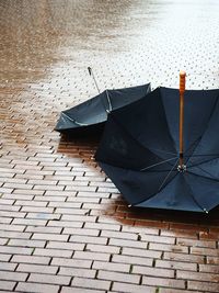 High angle view of umbrellas on wet cobbled street