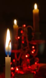 Close-up of lit candles burning at night