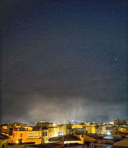 Illuminated buildings against sky at night