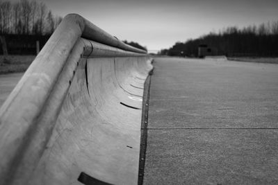 Close-up of railing on asphalt against sky