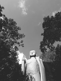 Low angle view of statue against trees