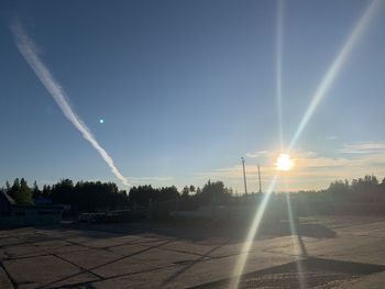 Scenic view of vapor trails in sky at sunset