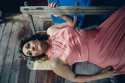 Portrait of woman lying down on wood