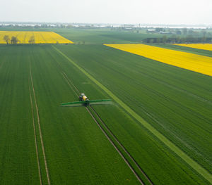 Tractor with field sprayer when applying pesticide against pesticide