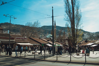 People on street in city against sky