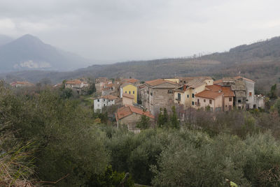 Townscape by tree mountain against sky