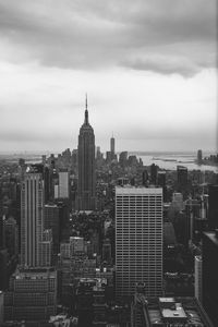 Buildings in city against cloudy sky